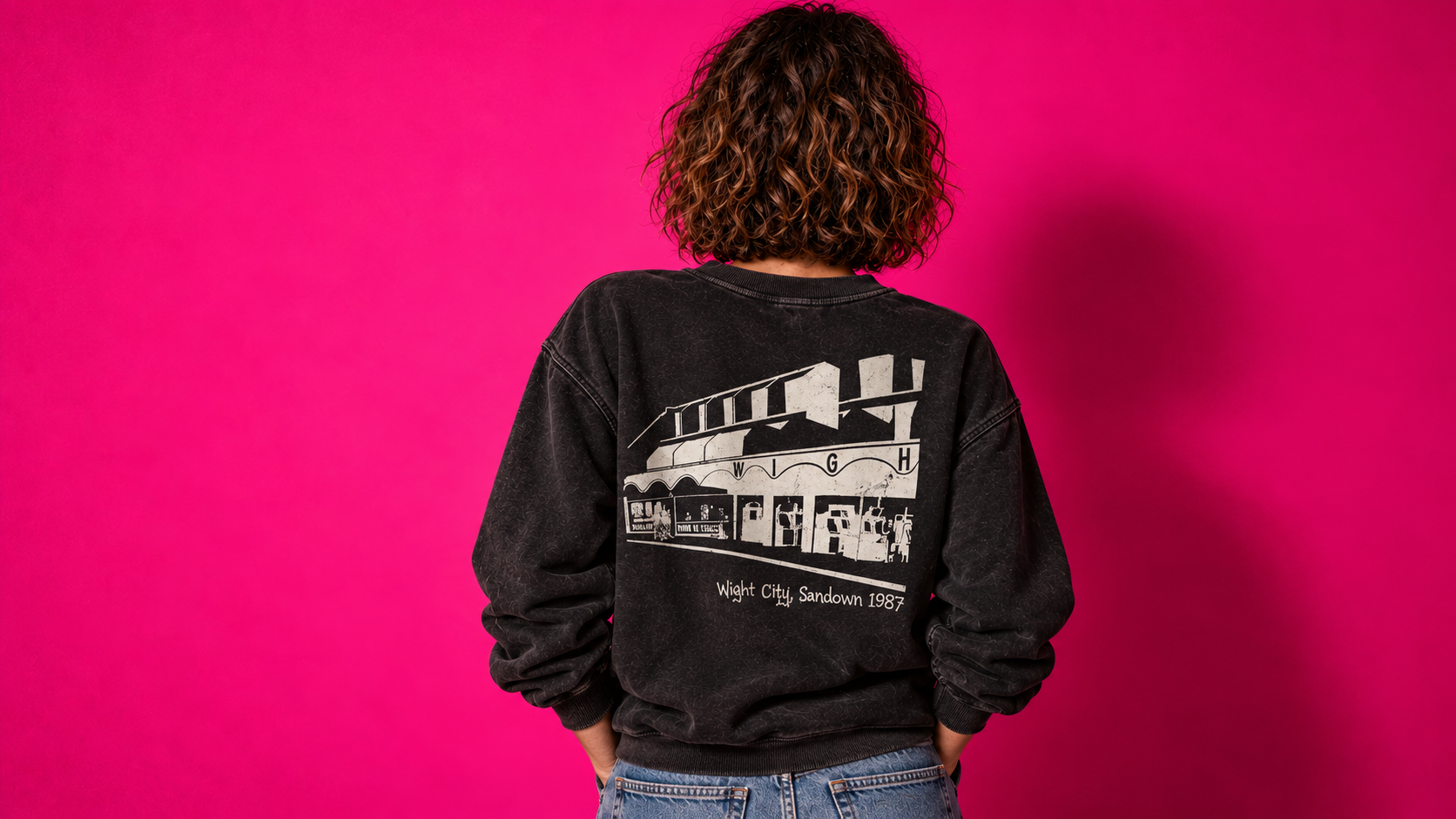 Back view of the same model wearing the washed charcoal sweatshirt with the large cream Wight City arcade graphic